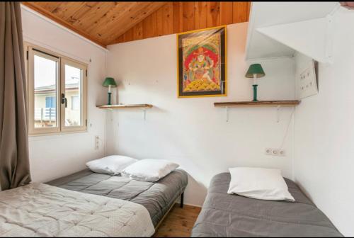 グリュイッサンにあるChalet sur pilotis 8 pers wifi 2 suites familles 50 m mer climの窓付きの客室で、ベッド2台が備わります。