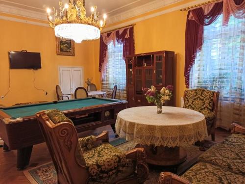 a living room with a pool table and a chandelier at Вілла Графа in Lviv