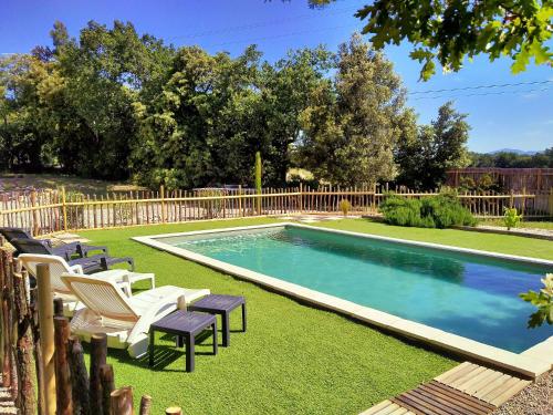 a swimming pool in a yard with chairs and a fence at "Au Jas" Agréable logement en Drôme provençale in Montségur-sur-Lauzon