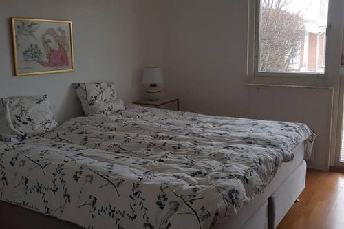 a bedroom with a large bed with a black and white comforter at Modern villa i Arild med spektakulär havsutsikt. in Arild