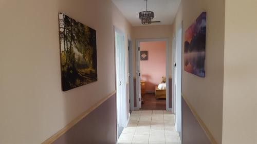 a hallway with paintings on the walls of a home at Pauleens Peaceful Place in Rochfortbridge