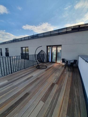 a deck with a bench on top of a building at Cotton House in Łódź