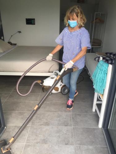 a woman in a hospital room with a vacuum at Aqua&Co Bellagio - Eco conscious stay in Bellagio