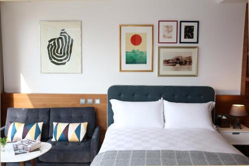 a bedroom with a bed and a couch at Little Tai Hang in Hong Kong
