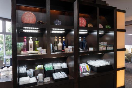 a store shelf with bottles of cosmetics and candles at Centre One Hotel Handa in Handa