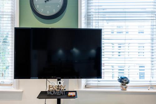 a large flat screen tv sitting in front of a window at Majestic Modern Flat in the heart of London in London