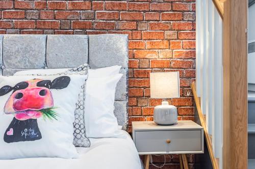 a bedroom with a bed with a brick wall at Majestic Modern Flat in the heart of London in London