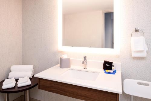 a bathroom with a white sink and a mirror at Holiday Inn Express Towson- Baltimore North by IHG in Towson