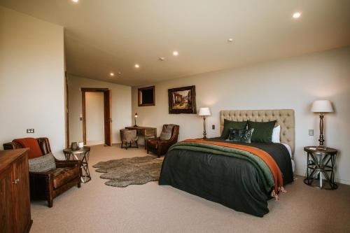 a bedroom with a bed and a chair and a desk at Stoneridge Estate in Queenstown