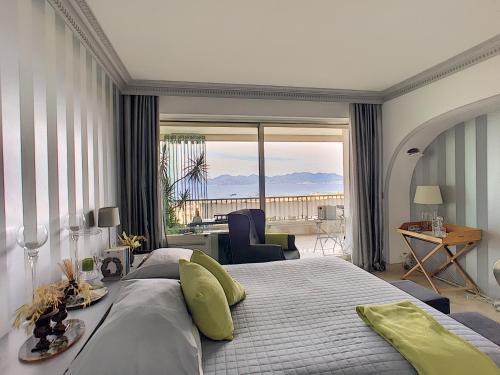 カンヌにあるFRGK "Prestige vue mer & piscine"のベッドルーム1室(大きなベッド1台、大きな窓付)