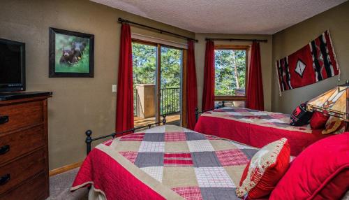 une chambre avec deux lits et une télévision et une fenêtre dans l'établissement Cedar Lower Condominium 2 Bedroom condo, à Estes Park
