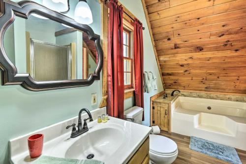 La salle de bains est pourvue d'un lavabo, de toilettes et d'un miroir. dans l'établissement Secluded Pleasant Mount Cabin with Deck and Fireplace!, à Pleasant Mount