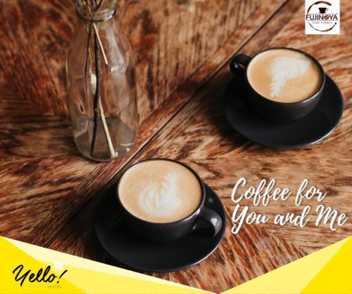 two cups of coffee sitting on a wooden table at Yello Hotel Cebu powered by Cocotel in Cebu City