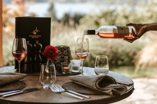 a person pouring wine into glasses on a table at Stoneridge Estate in Queenstown
