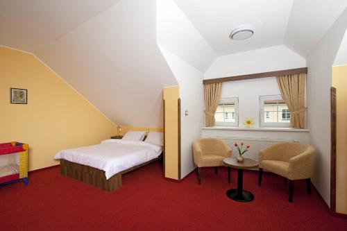 a bedroom with a bed and a table and chairs at Penzion Na Hvězdě in Ústí nad Labem