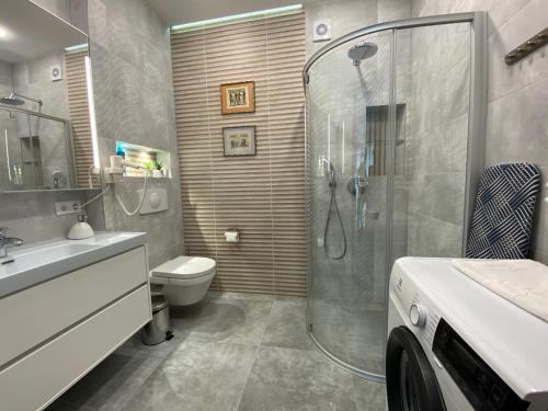uma casa de banho com um chuveiro, um WC e um lavatório. em Vila Vitalija em Palanga