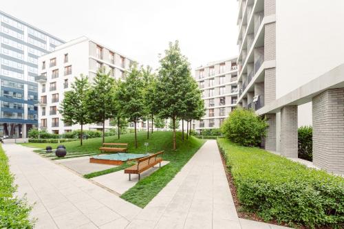 a park with benches and trees and buildings at Chill Apartments Mokotów Residence in Warsaw