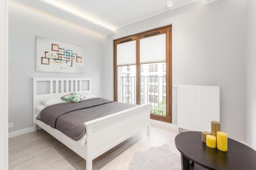 biała sypialnia z łóżkiem i stołem w obiekcie Chill Apartments Mokotów Residence w Warszawie