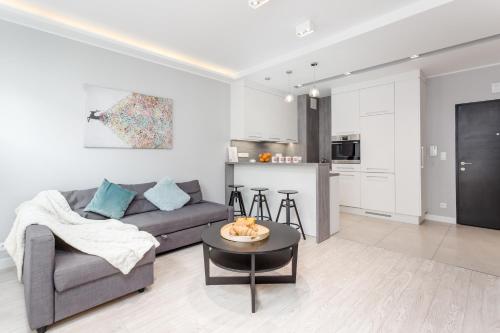 a living room with a couch and a table at Chill Apartments Mokotów Residence in Warsaw