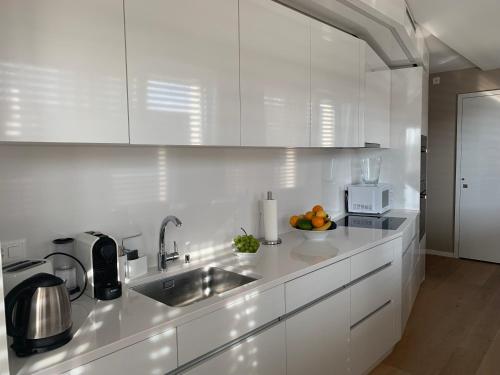 een witte keuken met een wastafel en een magnetron bij Luxury Penthouse Zurich in Zürich