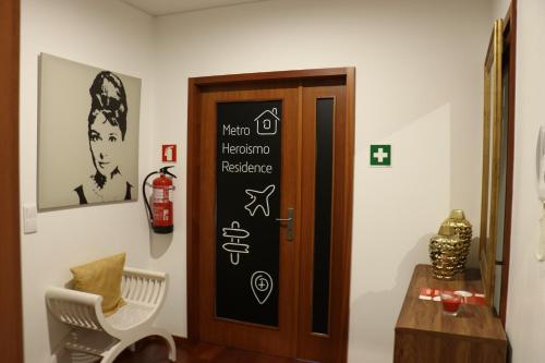 a bathroom with a toilet and a painting on the wall at Metro Heroismo Residence in Porto
