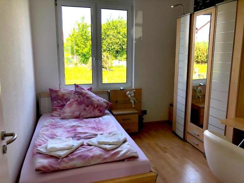 a bedroom with a bed with pink sheets and a window at Dreamapartment La Vigna Living mit eigenem Aussenpool & Sauna - Weil am Rhein in Weil am Rhein