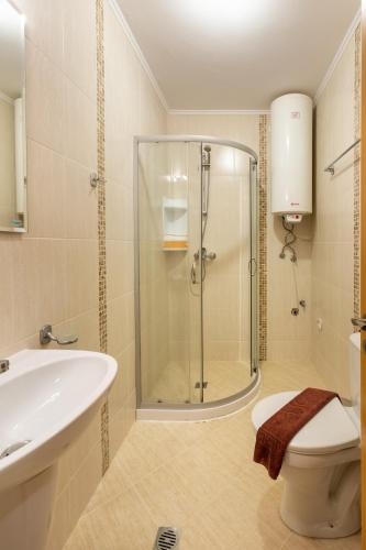 a bathroom with a shower and a toilet and a sink at Apartments Flora in Burgas