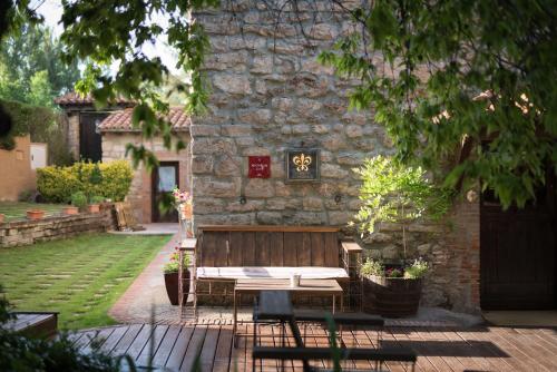 a wooden bench sitting in front of a stone building at Molino de Alcuneza Relais & Châteaux in Sigüenza