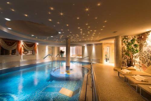 a large swimming pool in a hotel room with a swimming pool at Hotel Patrizia Dolomites Glamour in Moena