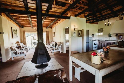a living room with a table and a kitchen at Valley Lakes CHALETS in Underberg