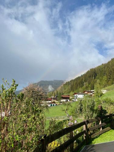 a fence in a field with houses in the background at Bauernhof Unterbichl in Flachau