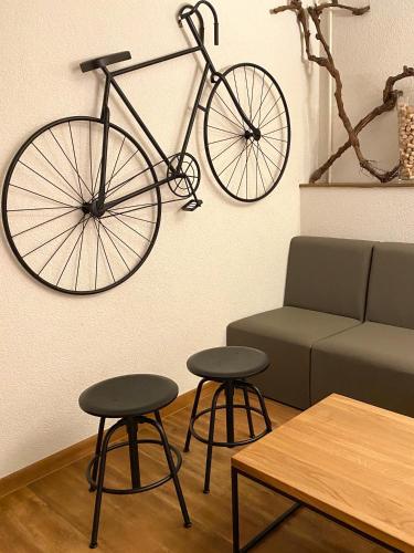 a bike hanging on a wall next to a couch at Hotel Deutsches Haus in Kitzingen