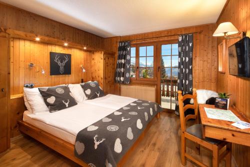 ein Schlafzimmer mit einem Bett und einem Schreibtisch mit einem Schreibtisch in der Unterkunft Petit Paradis in Crans-Montana