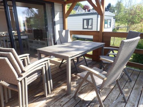 einen Holztisch und Stühle auf einer Terrasse in der Unterkunft Ferienpark Süderstapel in Süderstapel