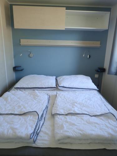 ein Bett mit zwei Kissen darüber in der Unterkunft Ferienpark Süderstapel in Süderstapel