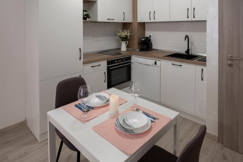 a kitchen with a table with plates and wine glasses at SOS CoMFORT in Burgas