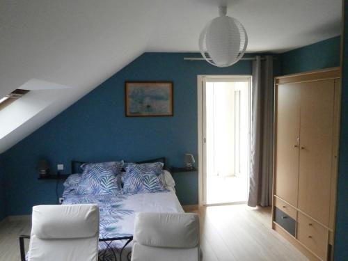 Mesquerにあるle bouche à oreilleの青いベッドルーム(ベッド1台、白い椅子2脚付)