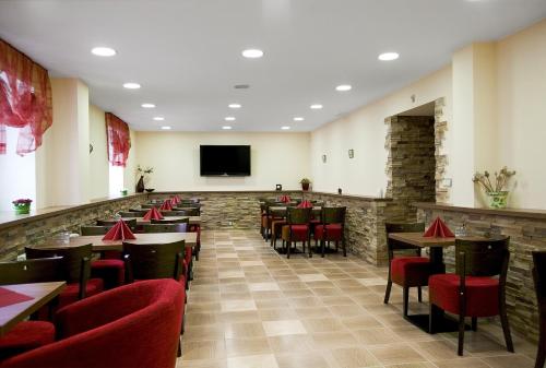 a restaurant with tables and chairs and a flat screen tv at Penzion Na Hvězdě in Ústí nad Labem