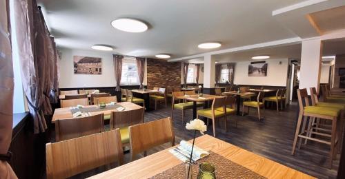 a restaurant with wooden tables and chairs and a brick wall at Hotel Engel in Kappel-Grafenhausen