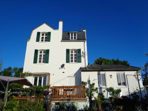 ein weißes Haus mit grünen Fenstern und einem Balkon in der Unterkunft vacances 34 in Le Crotoy