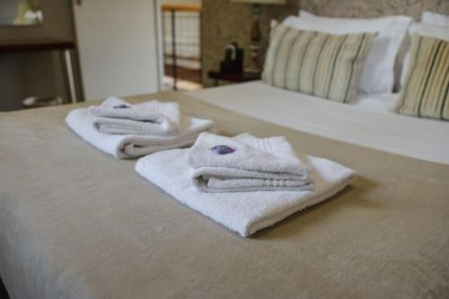 three towels are sitting on top of a bed at Elegant Lodge & Conference Center in Pongola