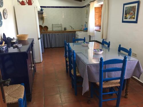 uma cozinha com mesa e cadeiras e uma cozinha com balcão em Casa La Dehesa em Huertas Bajas