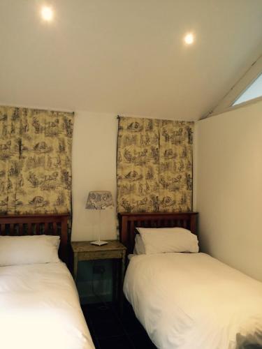 a bedroom with two beds and a lamp on a table at Hadrian's Barn in Heddon on the Wall