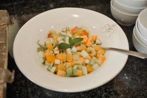 a white bowl of food with vegetables on a table at Elegant Lodge & Conference Center in Pongola