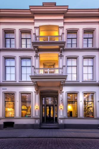 a large white building with a balcony on it at FINCH Boutique Hotel, downtown in Deventer