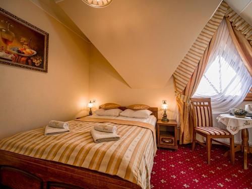 a bedroom with a bed with towels on it at Pensjonat Zbójecki Dwór - ATRAKCYJNY PAKIET ŚWIĄTECZNY - blisko basenów termalnych i szlaków górskich in Bukowina Tatrzańska