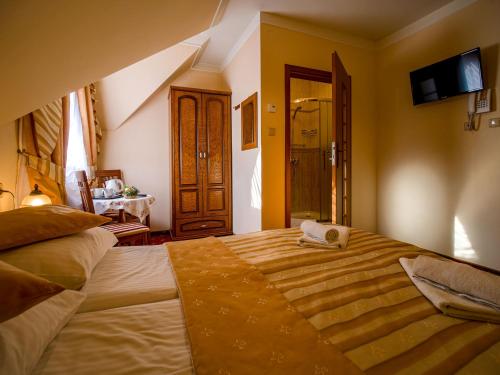 a bedroom with a large bed with a towel on it at Pensjonat Zbójecki Dwór - ATRAKCYJNY PAKIET ŚWIĄTECZNY - blisko basenów termalnych i szlaków górskich in Bukowina Tatrzańska