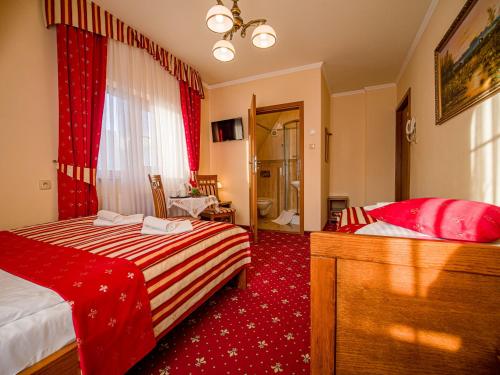 a bedroom with two beds and a red carpet at Pensjonat Zbójecki Dwór - ATRAKCYJNY PAKIET ŚWIĄTECZNY - blisko basenów termalnych i szlaków górskich in Bukowina Tatrzańska