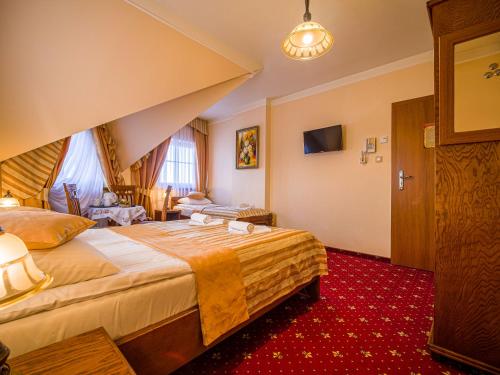 a hotel room with a large bed and a red carpet at Pensjonat Zbójecki Dwór - ATRAKCYJNY PAKIET ŚWIĄTECZNY - blisko basenów termalnych i szlaków górskich in Bukowina Tatrzańska