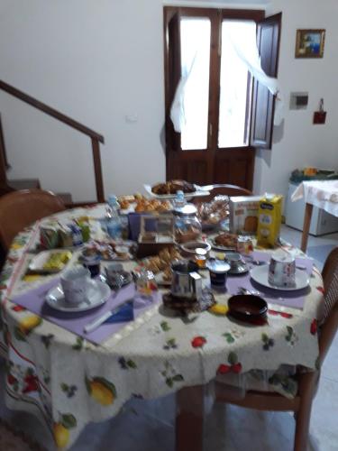 une table avec une nappe sur laquelle se trouve de la nourriture dans l'établissement B&B S'ARROSA ANTIGA, à Santadi